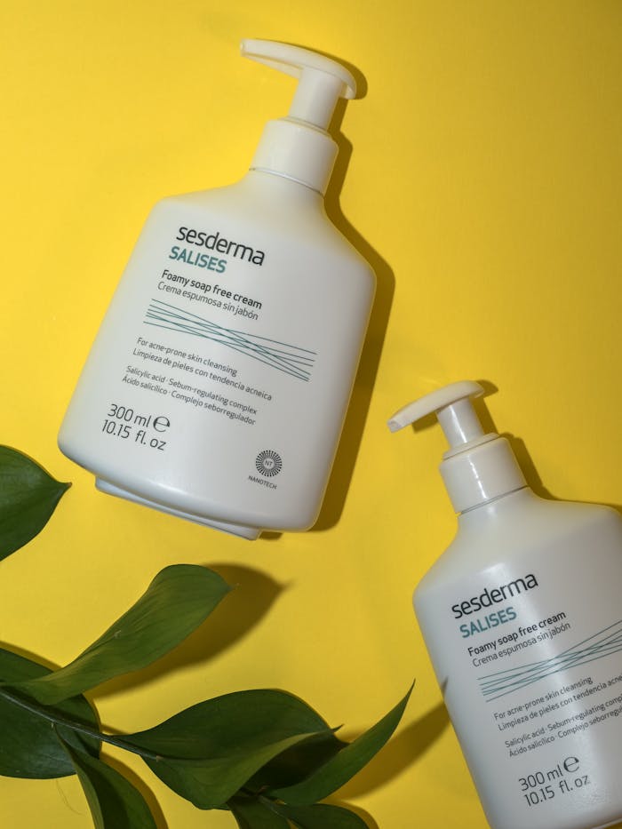 Two bottles of Sesderma Salises cream on a yellow background with green leaves.