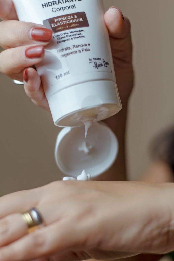 Close-up of a woman applying body lotion from a tube for a daily skincare routine.