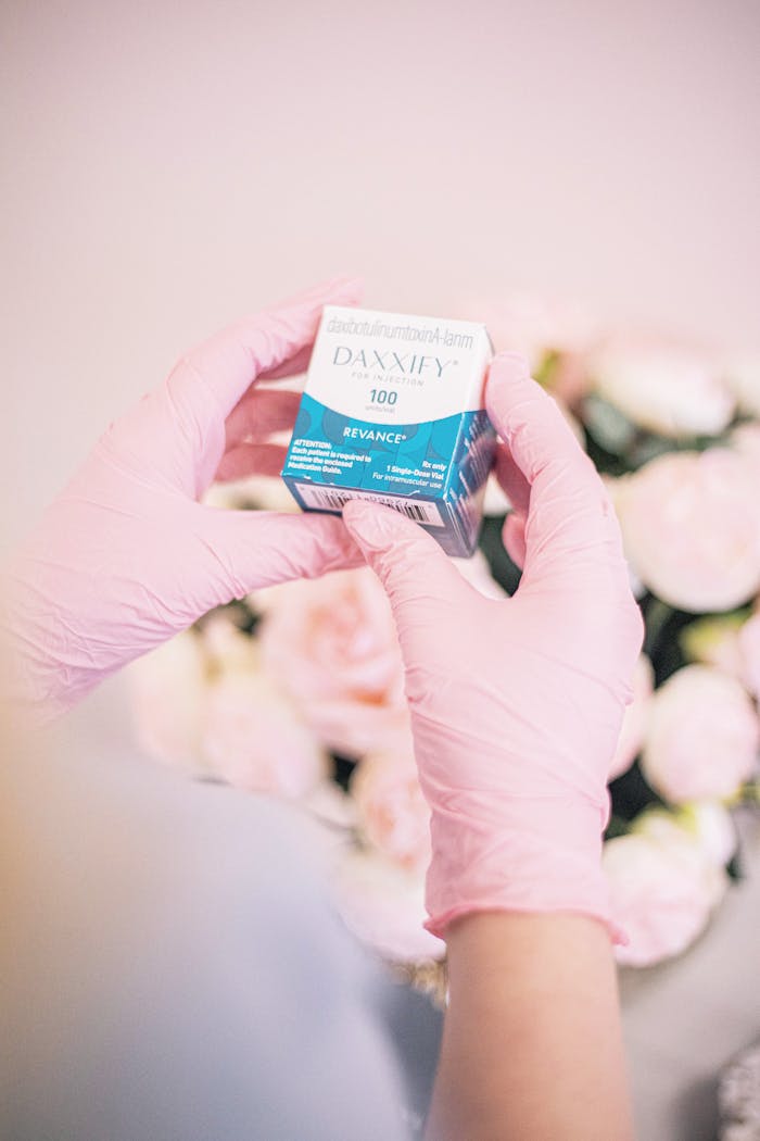 Close-up of aesthetic professional preparing cosmetic treatment with a floral backdrop.