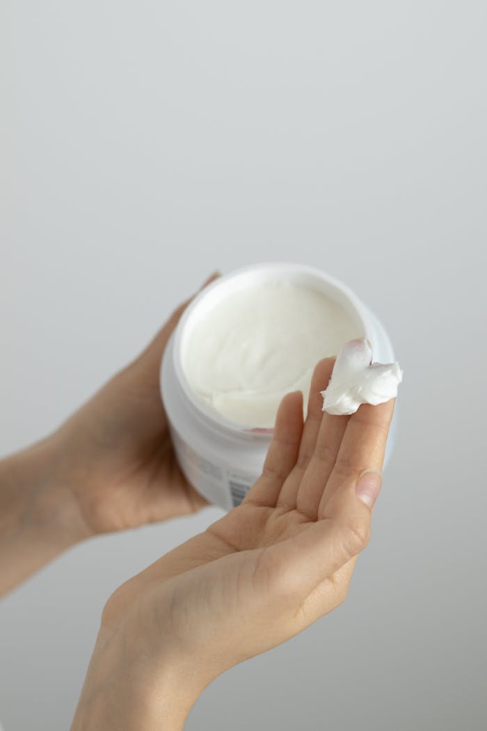 Close-up of a woman applying moisturizing cream on her hands, highlighting skincare routines.